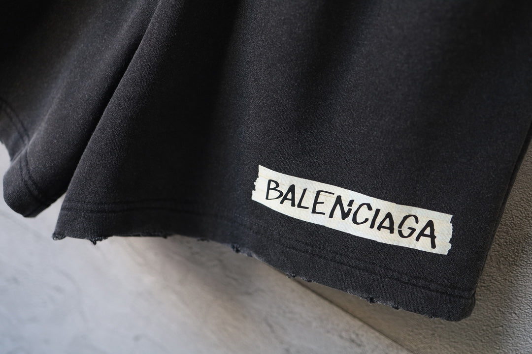 Balenciaga logo patch on dark charcoal pant leg hem