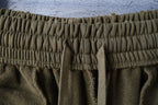 Olive shorts close-up of elastic waistband texture and gathered seams
