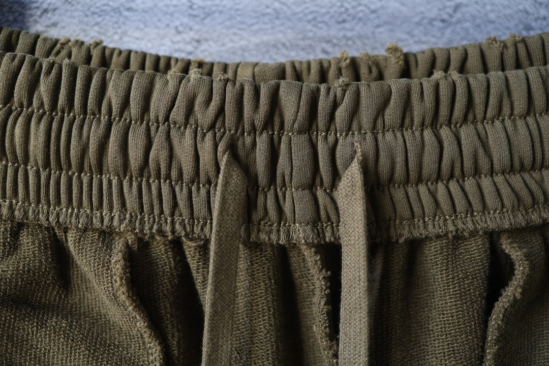 Olive shorts close-up of elastic waistband texture and gathered seams