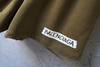 Olive shorts with Balenciaga logo patch on the hem