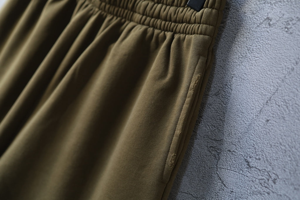 Olive shorts with stitched side seam and pleated fabric detail