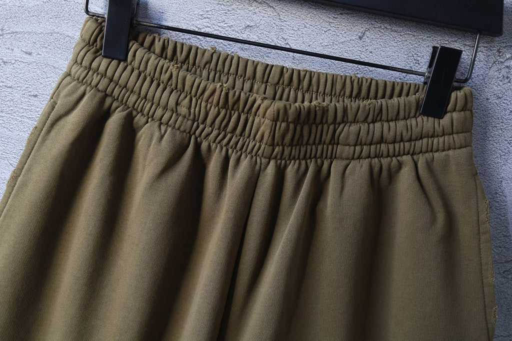 Olive shorts close-up of elastic waistband and pleated front
