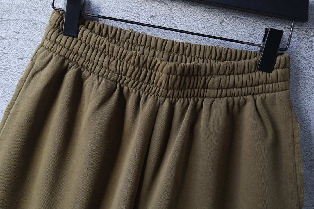 Olive shorts close-up of elastic waistband and pleated front