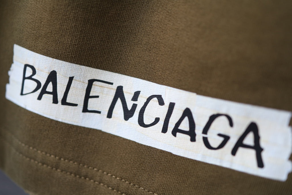 Olive shorts with Balenciaga logo patch near the waistband
