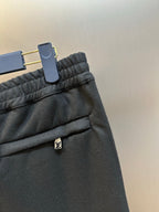 Louis Vuitton dark pants close-up of elastic waistband and LV logo patch