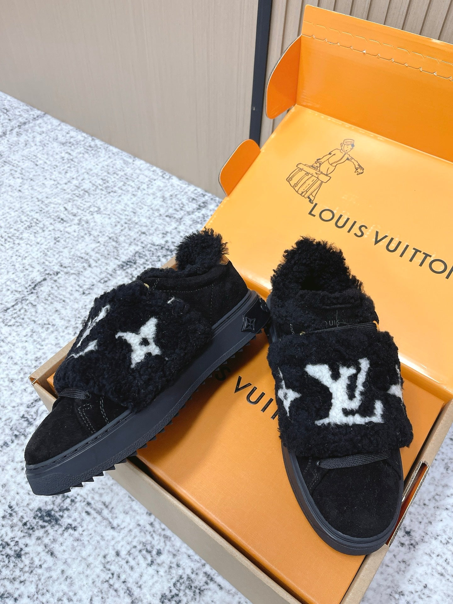 Louis Vuitton black plush sneakers with white star logo and padded collar