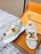 Shearling slip-on sneakers, light gray with tan monogram, angled view in box