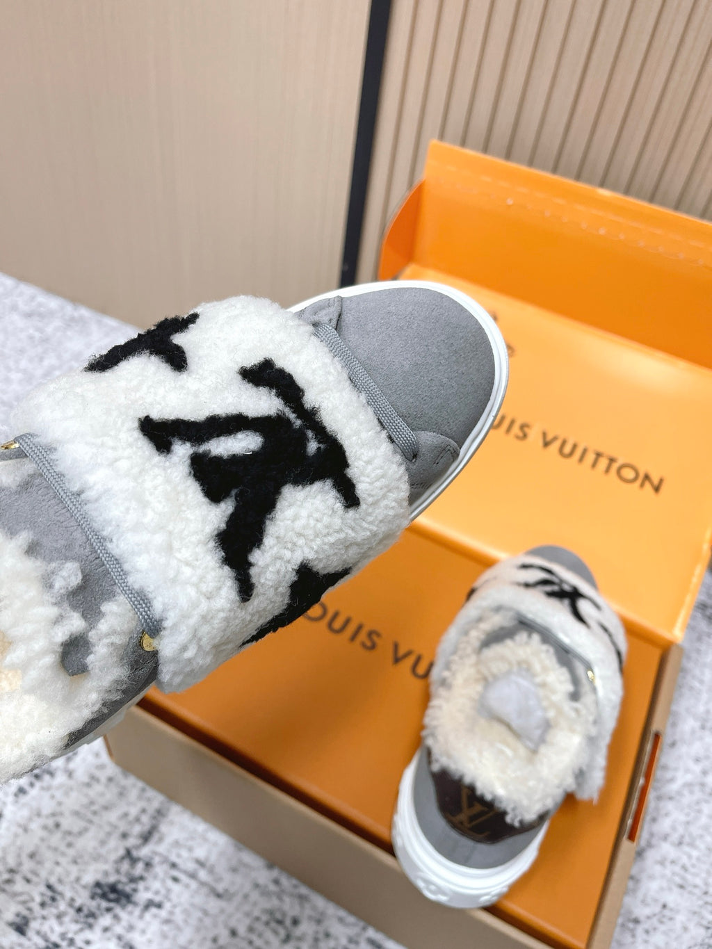 Louis Vuitton unisex sneakers, white sherpa strap with black star-like logo on gray low-top