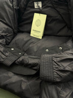 Black puffer jacket with Burberry hang tag and snap-button cuff details