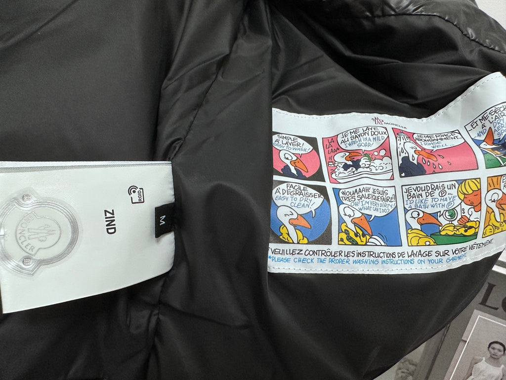 Black puffer jacket lining with colorful graphic print and small white label