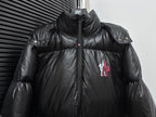 Black long puffer jacket front view with zipper, shoulder snap badge, chest logo
