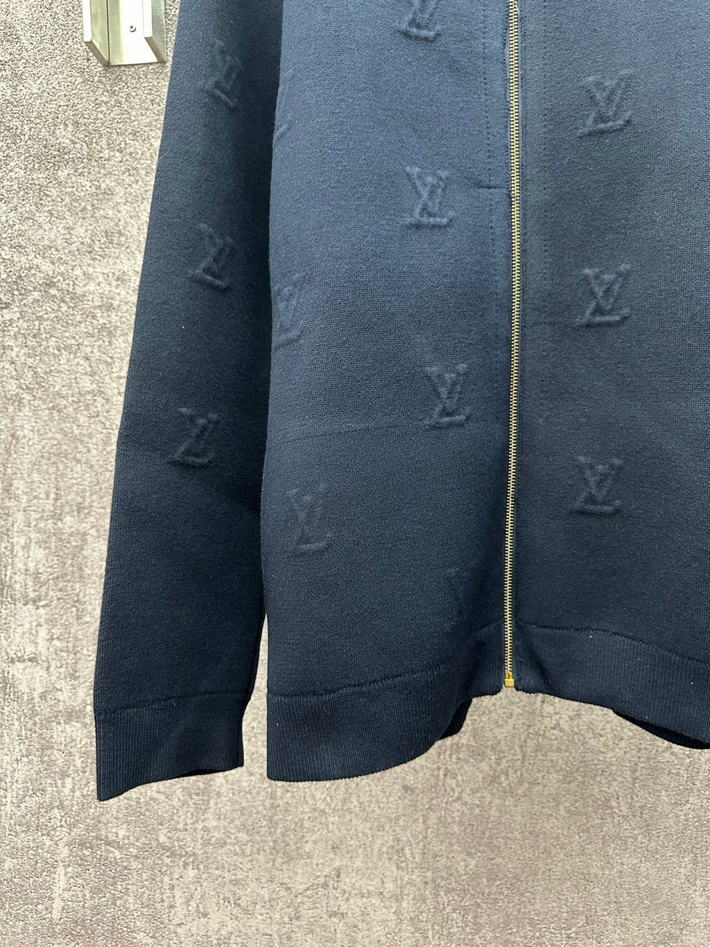 Dark blue long-sleeve zip jacket close-up of sleeves and subtle monogram
