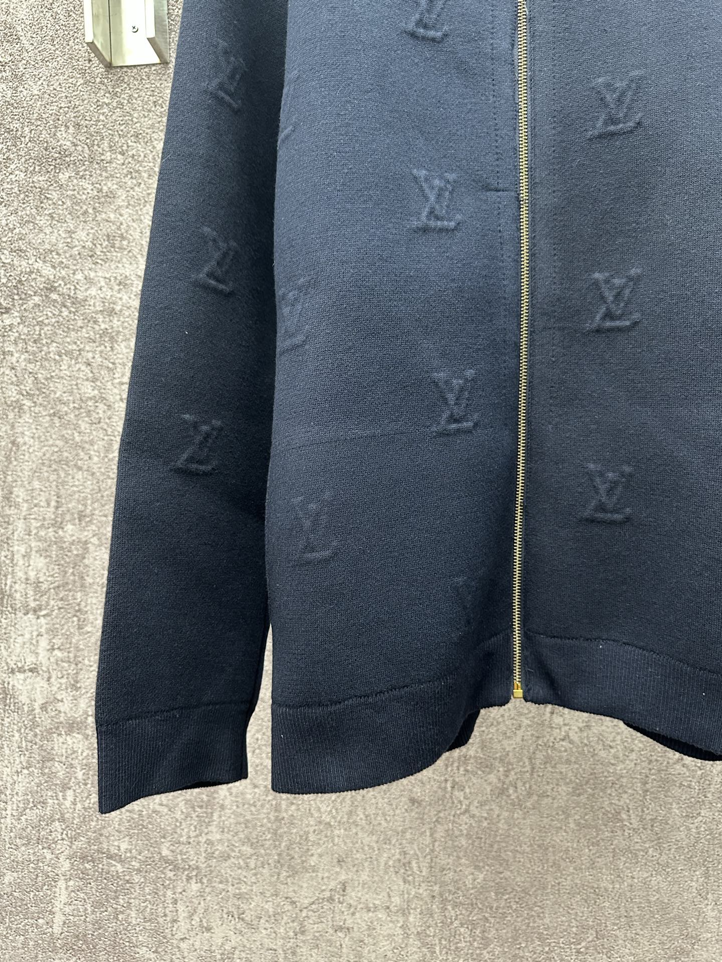 Dark blue long-sleeve zip jacket close-up of sleeves and subtle monogram