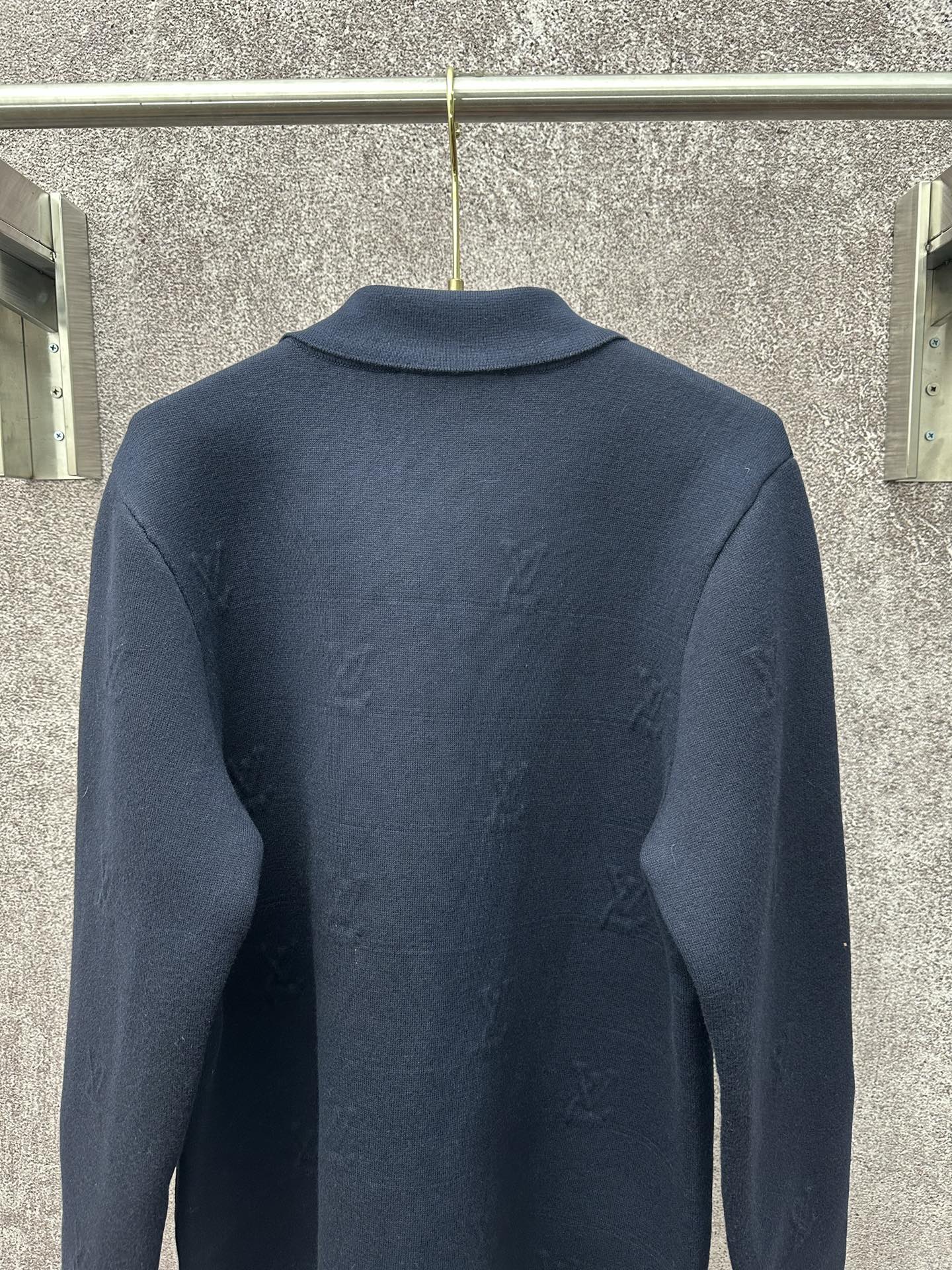 Dark blue long-sleeve zip jacket back view with subtle monogram pattern