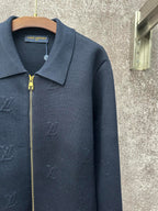 Dark blue long-sleeve zip jacket detail with gold zipper and pointed collar
