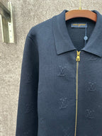 Dark blue long-sleeve zip jacket with pointed collar and subtle monogram pattern