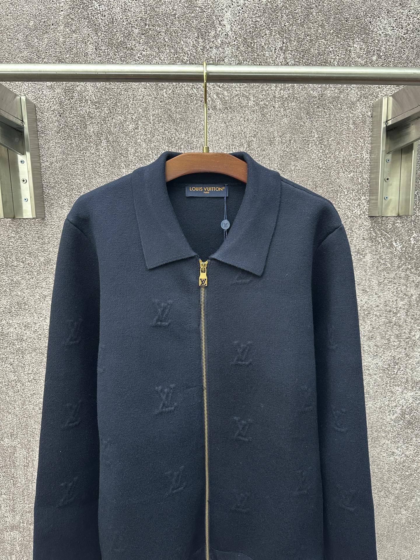 Dark blue long-sleeve zip jacket with pointed collar and gold zipper pull
