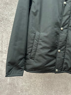 Long puffer jacket side view, dark green with ribbed hem and button placket