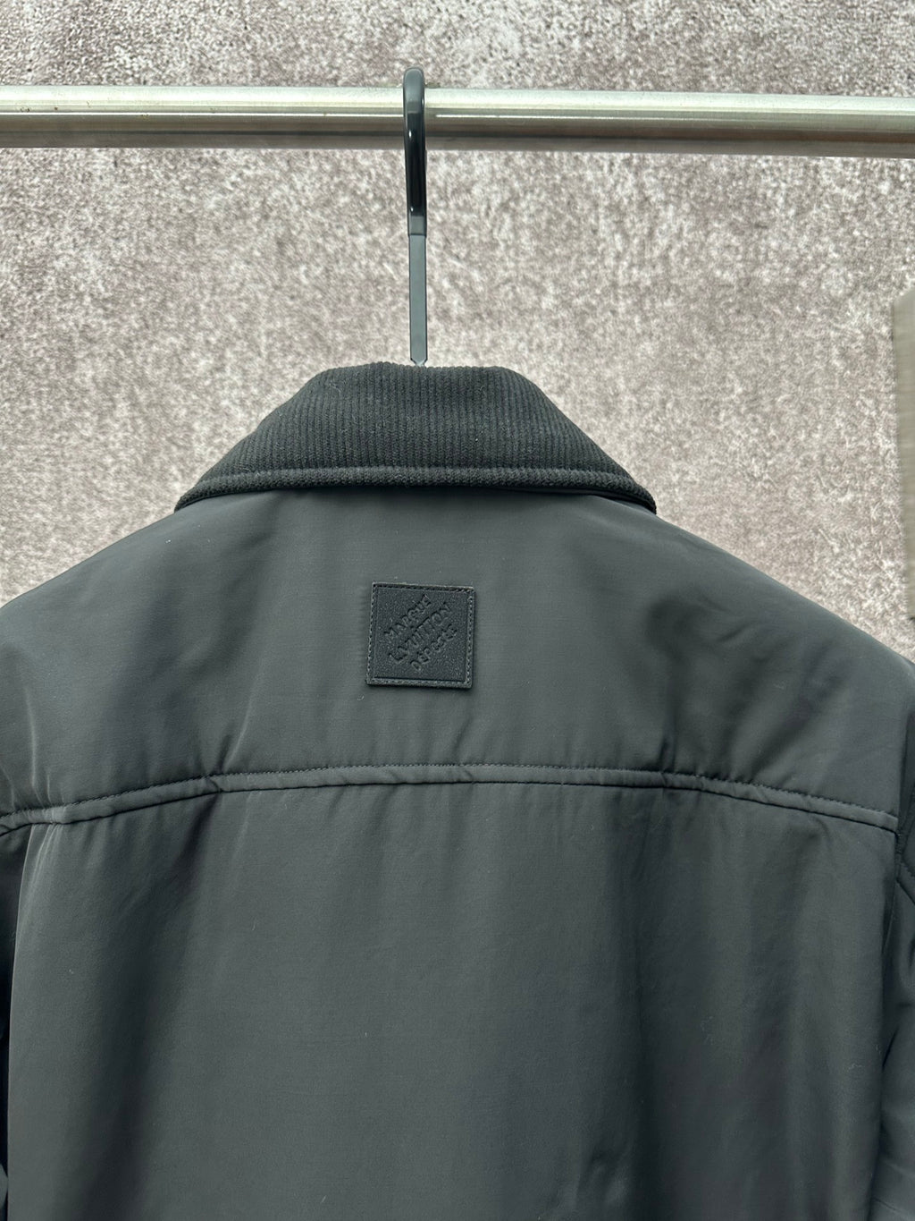Long puffer jacket back, dark green with small logo patch under the collar