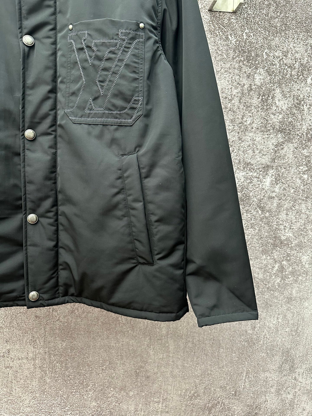 Long puffer jacket sleeve and hem, dark green with stitched logo pocket detail