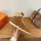 Hermes unisex suede sneaker side with white laces and tan shearling trim, held up