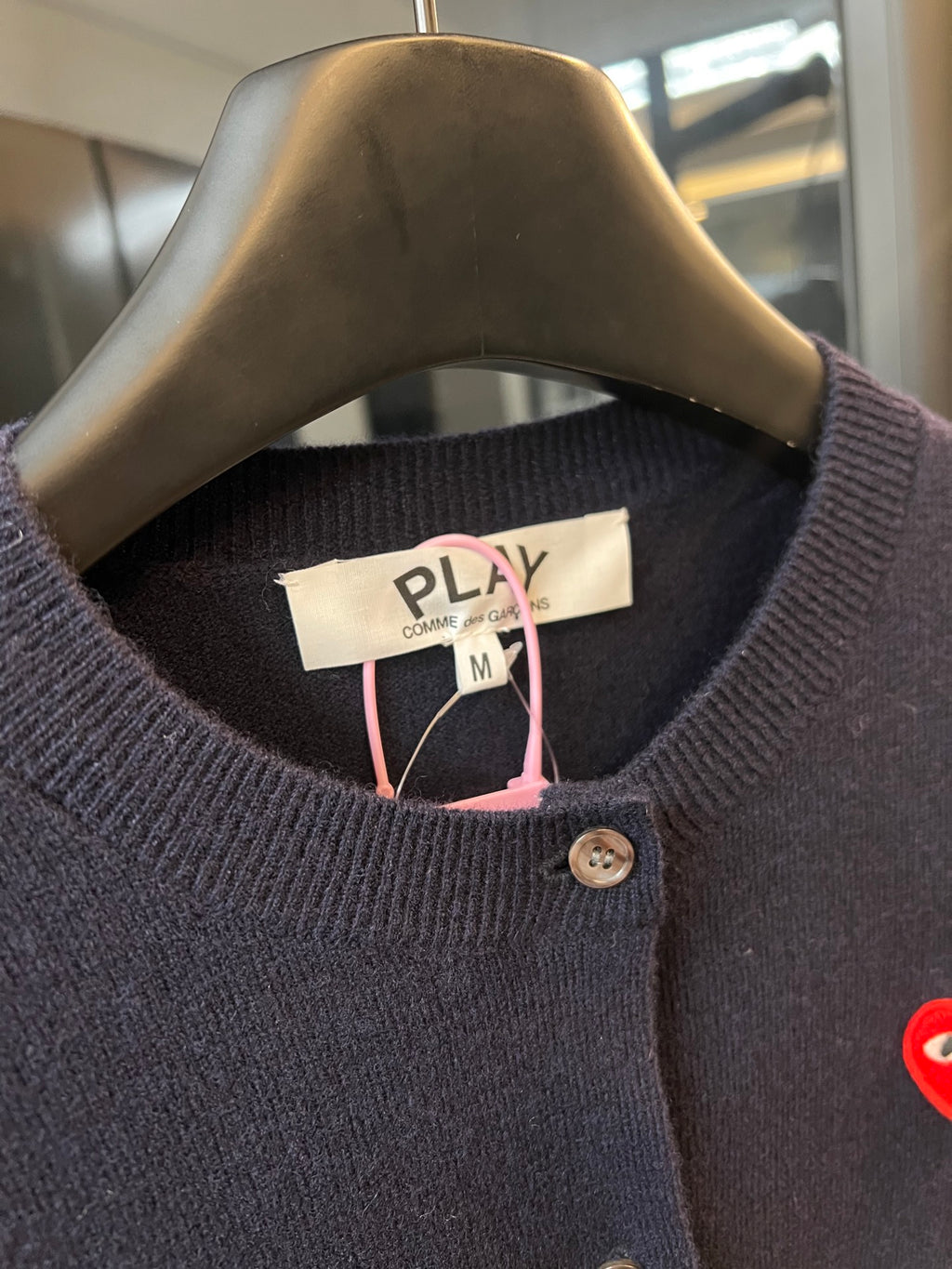Dark navy knit cardigan neckline with PLAY label, button front, and pink drawstring accents