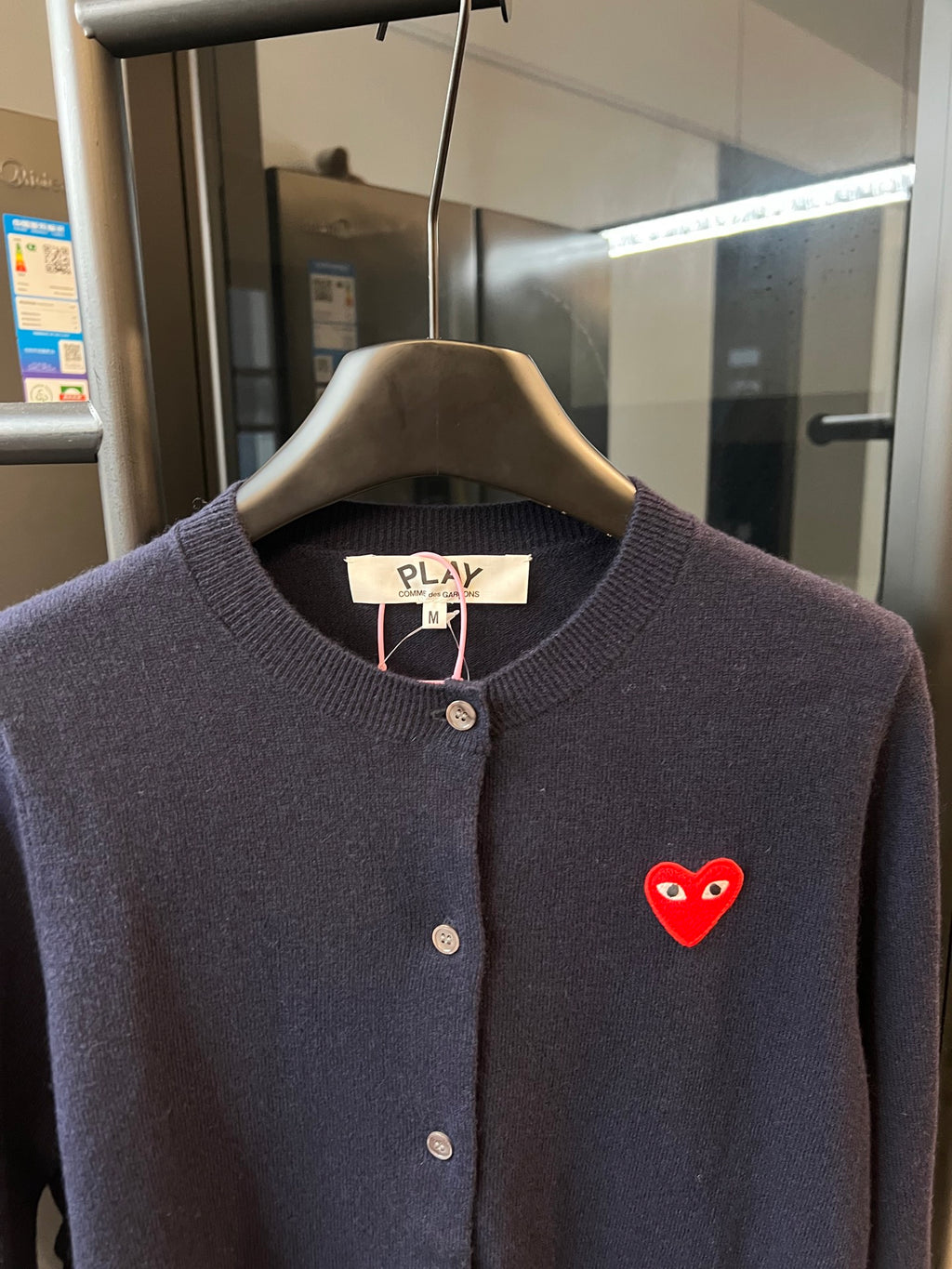 Dark navy knit cardigan with button placket, ribbed collar, and red heart patch