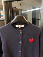 Dark navy knit cardigan with button placket, ribbed collar, and red heart patch