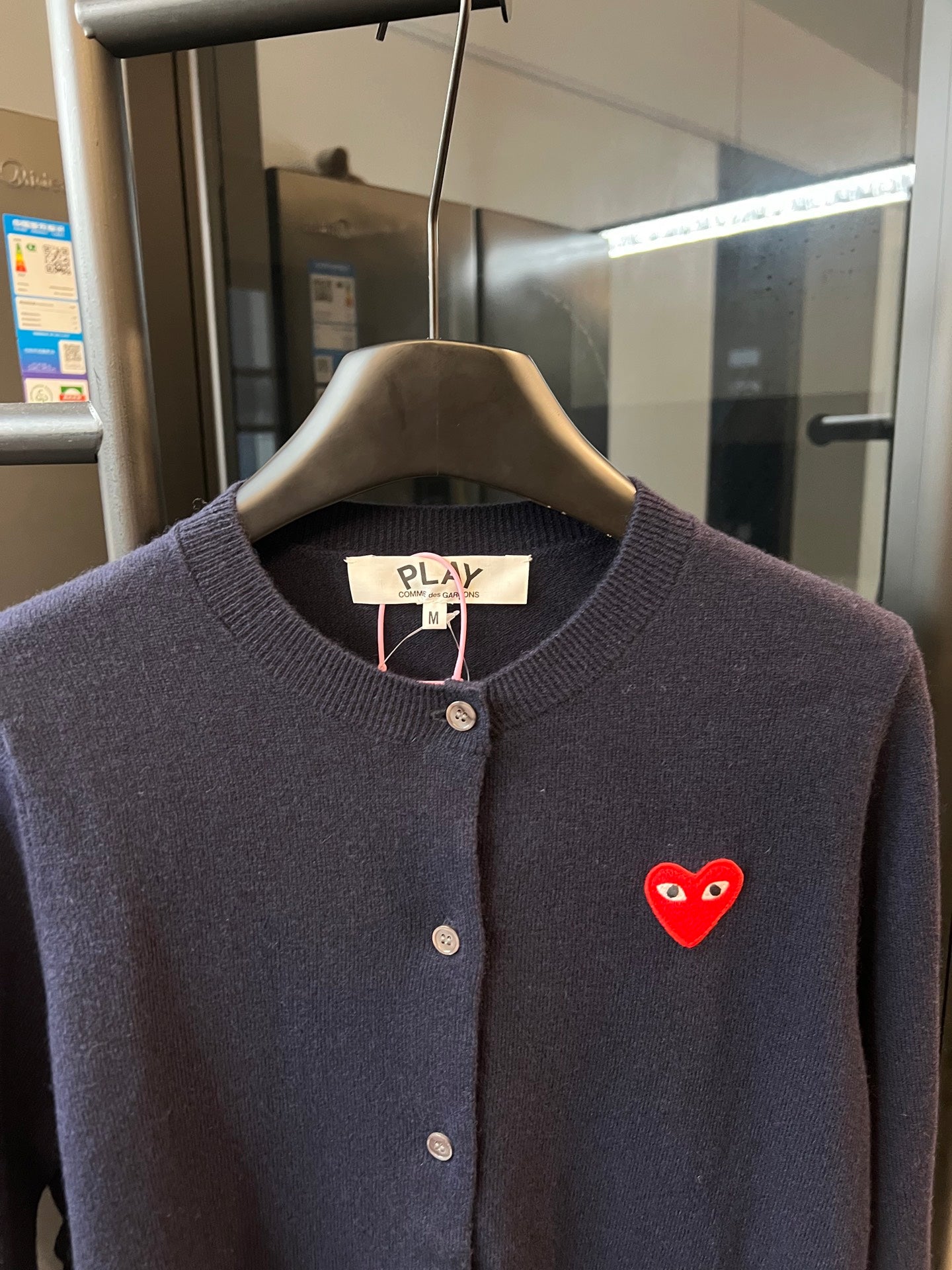 Dark navy knit cardigan with button placket, ribbed collar, and red heart patch
