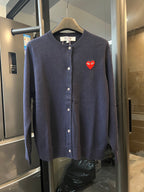 Dark navy knit cardigan with button front and small red heart patch on the left chest