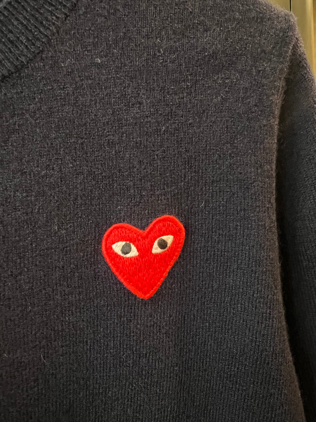 Red heart applique on dark navy knit cardigan chest