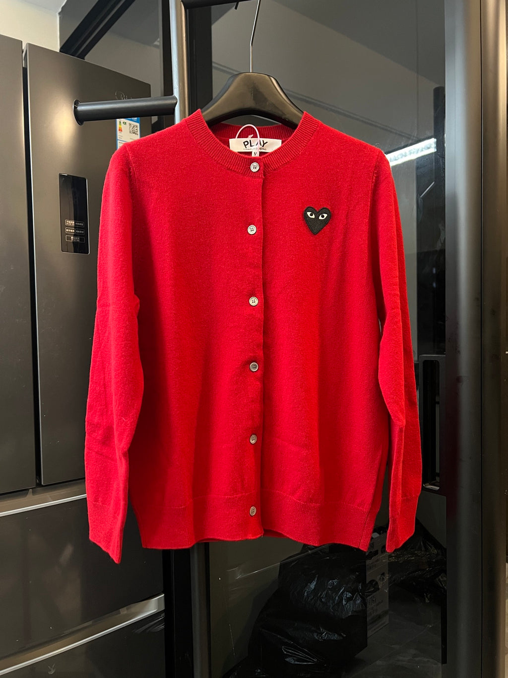 Red knit cardigan sweater with button front and black cat-face heart applique
