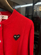 Red knit cardigan shoulder with black cat-face heart applique and ribbed neckline