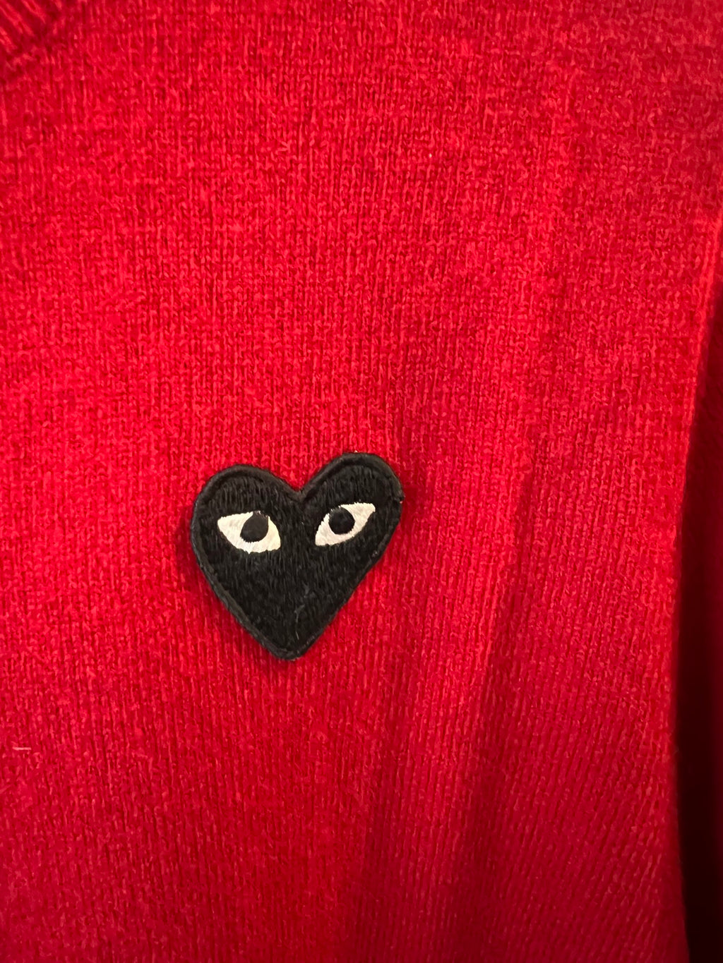 Black cat-face heart applique on red knit cardigan fabric