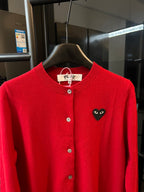 Red knit cardigan with black cat-face heart applique on the left chest and button front