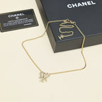 Gold-tone chain necklace with bow pendant, shown with black gift box