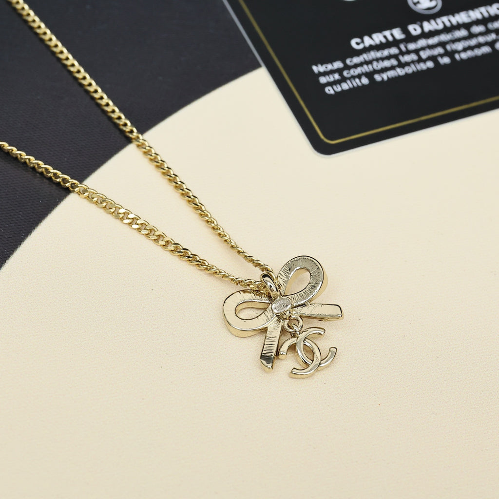 Gold-tone chain necklace with bow pendant charm detail