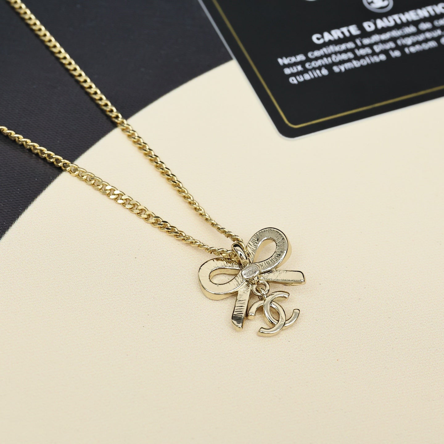 Gold-tone chain necklace with bow pendant charm detail