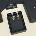Gold-tone drop earrings with rhinestone hoops and bow Chanel charms in gift box