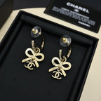Gold-tone hoop drop earrings with rhinestone bands and bow Chanel charms