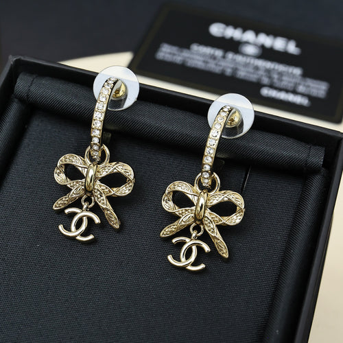 Gold-tone drop earrings with rhinestone hoop and bow charm with Chanel logo
