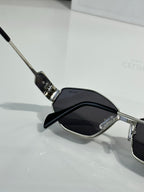 Metal sunglasses with dark lenses and clear nose pads, close-up view