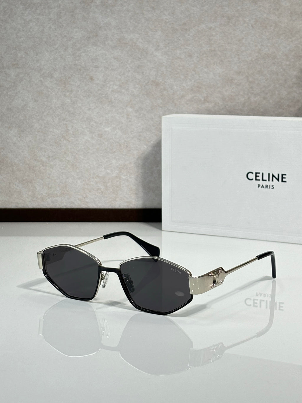 Black-and-gold sunglasses with dark lenses and gold bridge detail, front view
