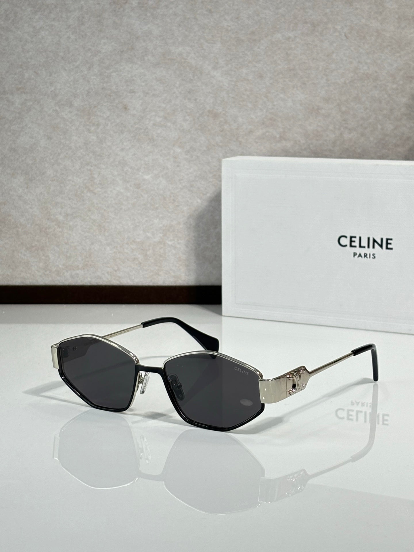Black-and-gold sunglasses with dark lenses and gold bridge detail, front view