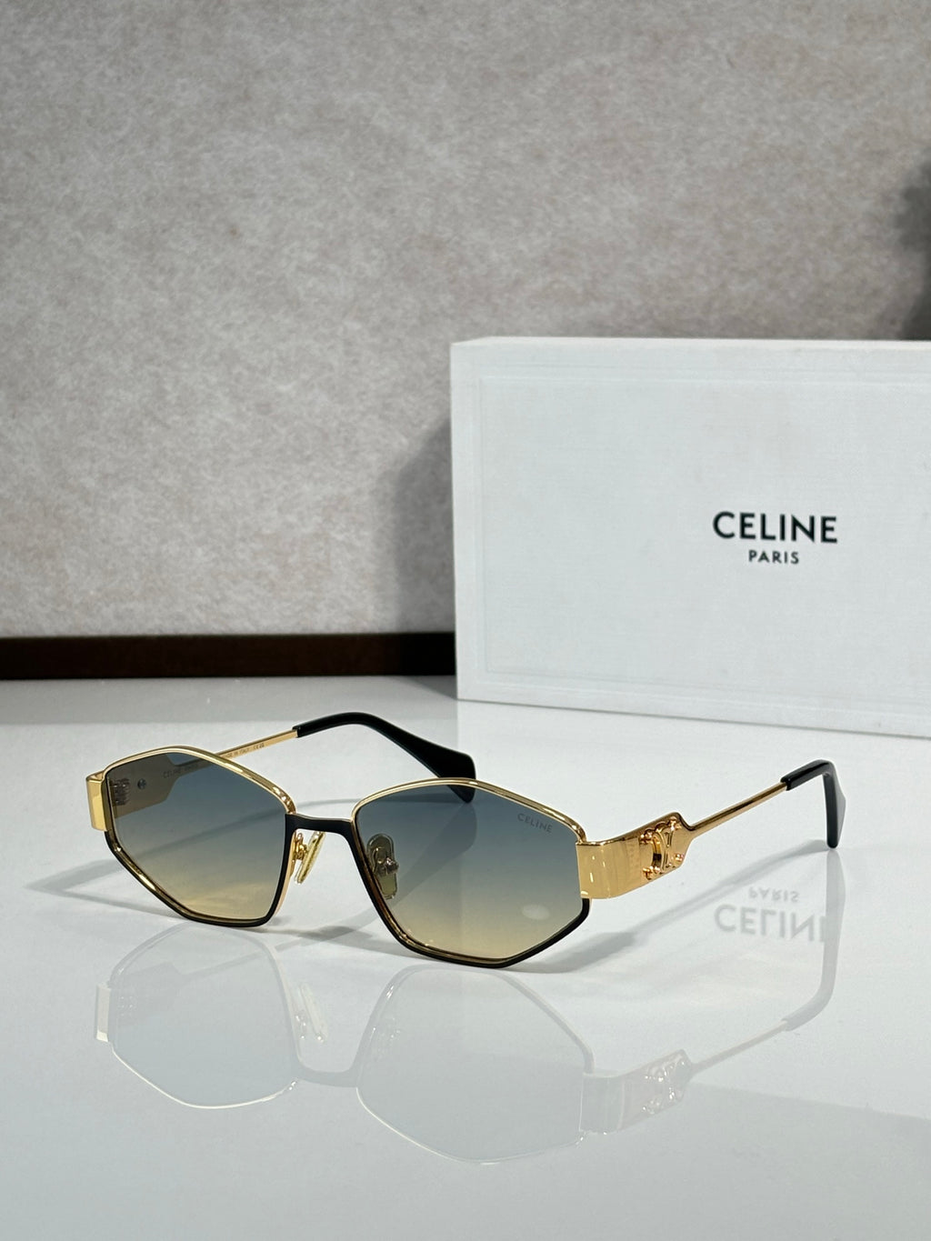 Gold-and-black sunglasses with dark lenses, angled front view