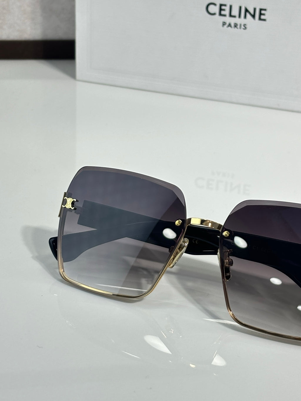 Celine sunglasses with dark lenses and gold-tone hinges, square cat-eye profile view