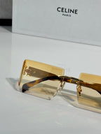 Celine sunglasses close-up with amber rectangular lenses and gold frame with engraved details