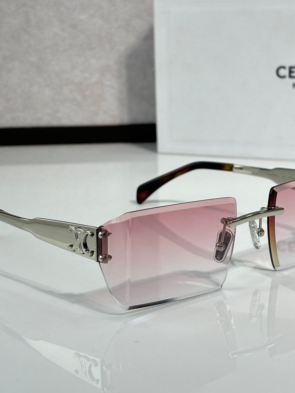 Celine sunglasses with pink-tinted rectangular lenses, clear front, and tortoise temple tips