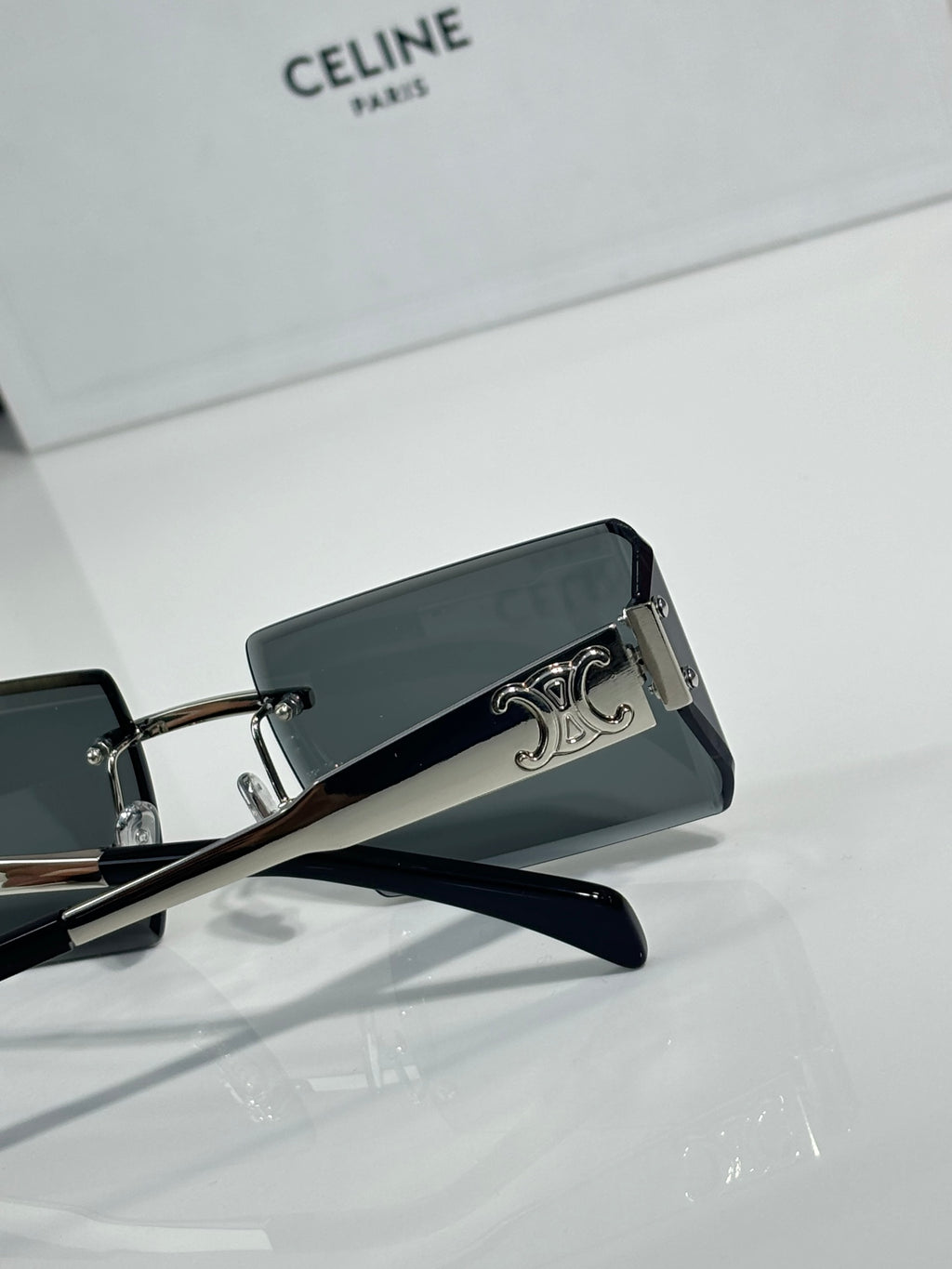 Celine sunglasses with dark rectangular lenses, black frame, and silver temple emblem