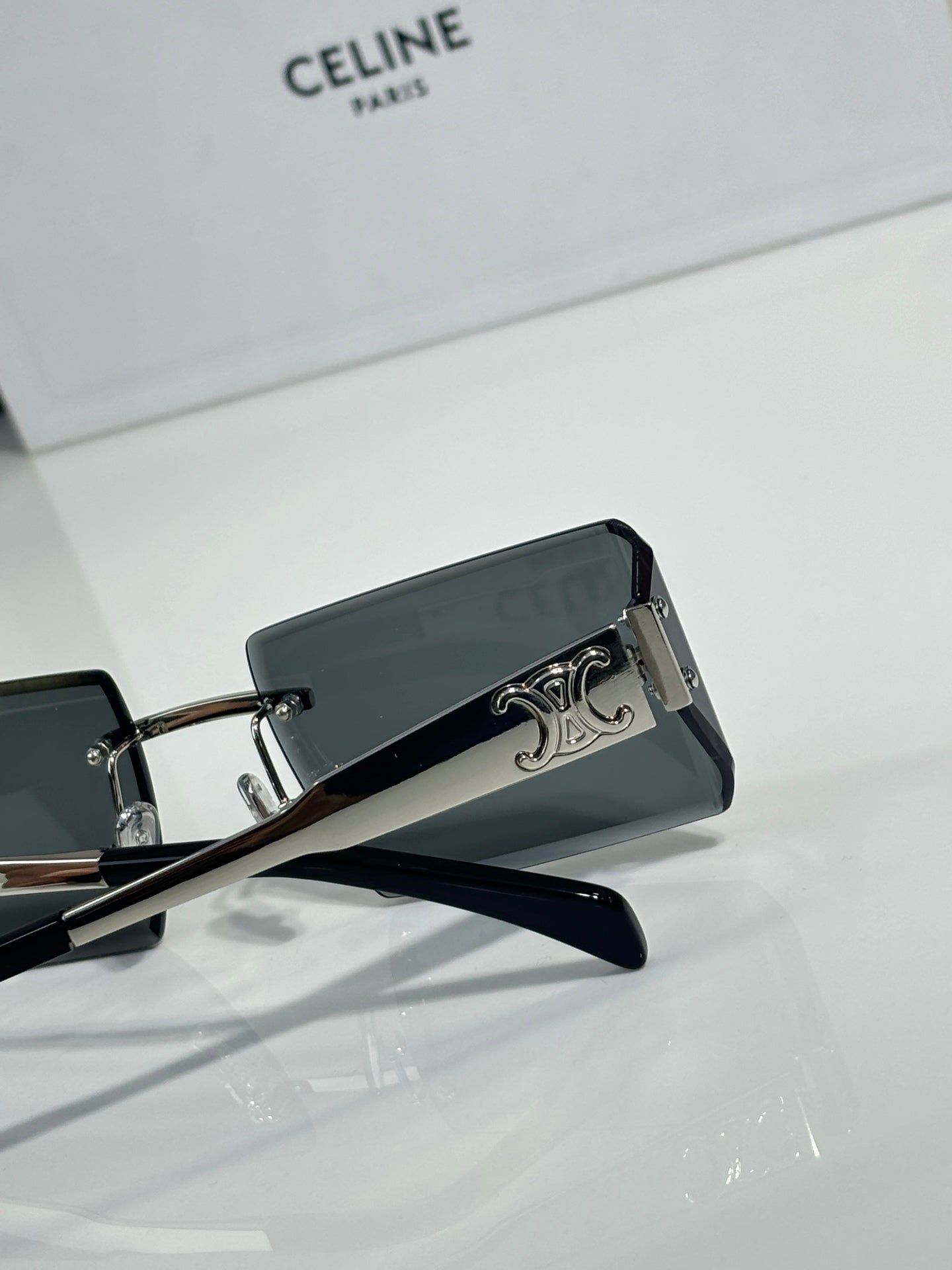 Celine sunglasses with dark rectangular lenses, black frame, and silver temple emblem